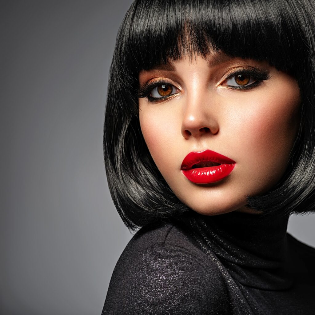 Beautiful brunette girl with red lips and black bob hairstyle.